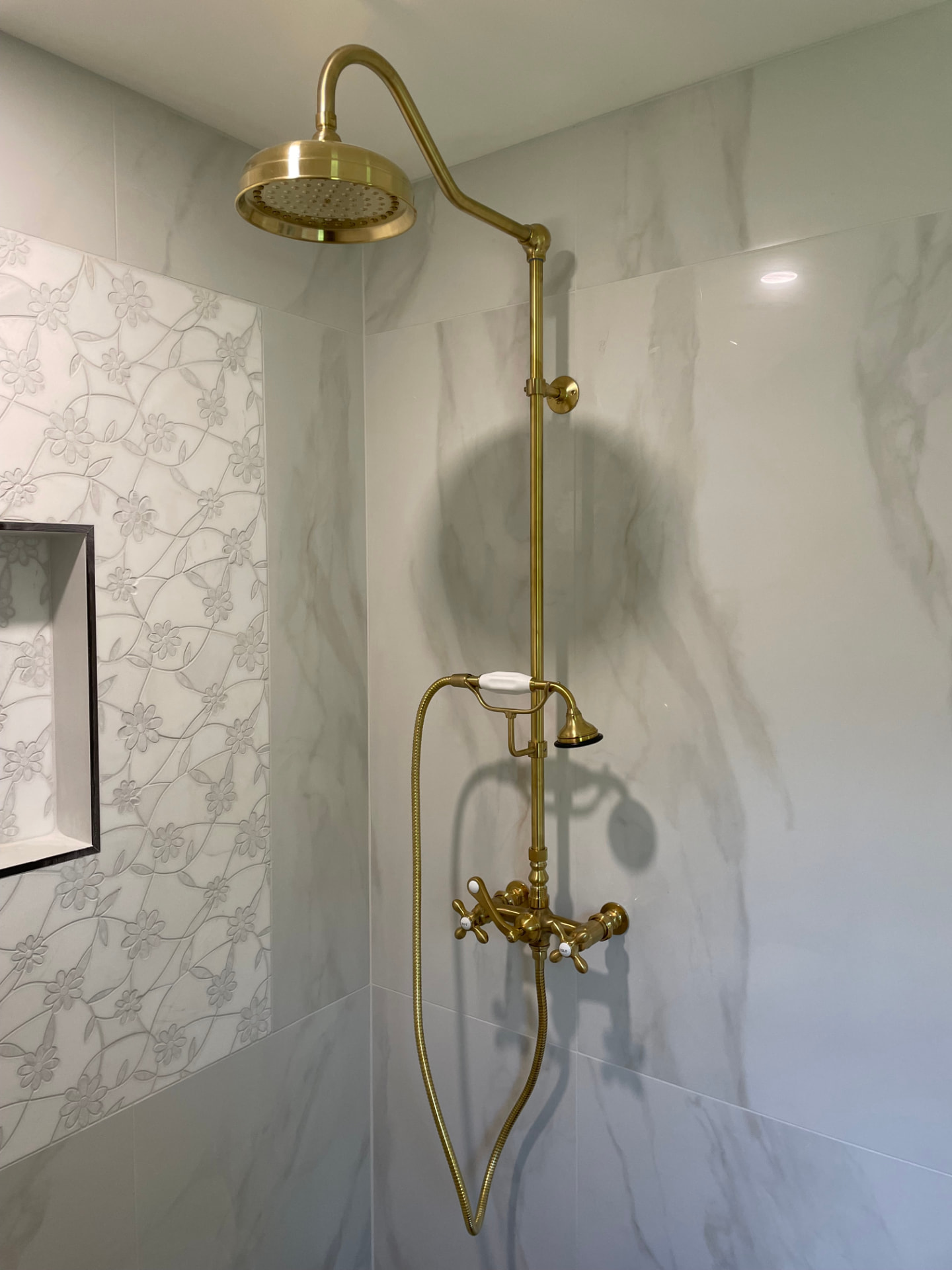 Brass rainfall shower fixture in a finished bathroom remodel by Top Shelf Plumbing & Heating