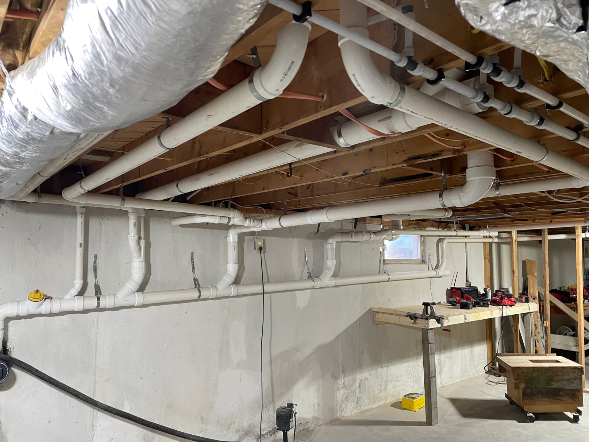 PVC drain and copper pipe installation in a basement remodel rough-in by Top Shelf Plumbing & Heating